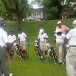 Youth receiving instruction from golf professional William Lewis, PGA