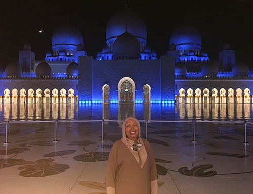 Traveler Denese Powell in front of The Sheikh Zayed Grand Mosque which stands out as one of the world's largest mosques, and the only one that captures unique interactions between Islam and world cultures. The largest mosque in the country, it is the key place of worship for daily prayers, Friday gathering and Eid prayers.
