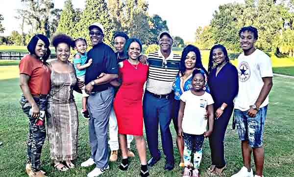 (L-R) One big happy family Traci, Imani, Reggie holding his grand-daughter Rayah, Gene, Bernita, Eddie Jr., Tamiya, Terra (little girl standing), Mia, Regan. (photo courtesy Smith family)